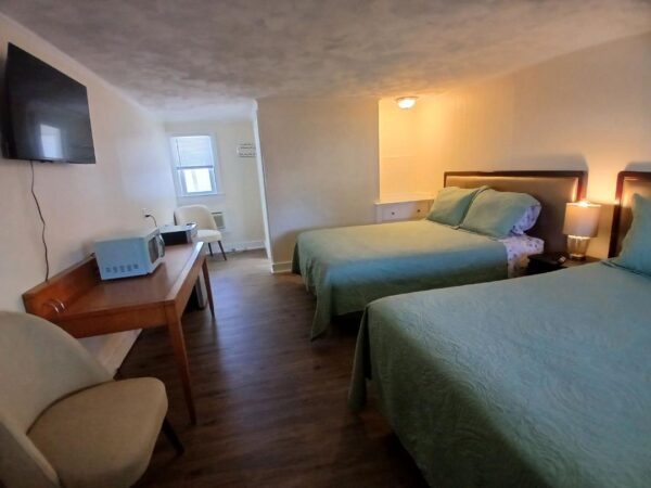 Hotel room with two beds and a desk.